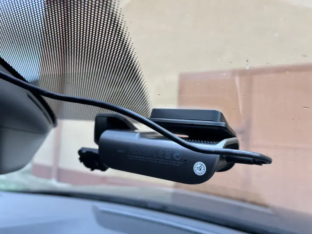 Przewód zasilający wystaje z kamery po prawej stronie. Bardziej ergonomiczne jest wyprowadzenie bezpośrednio przy uchwycie.