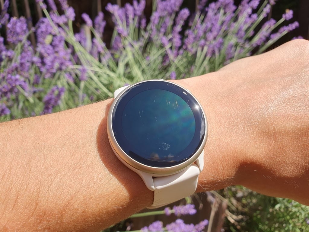 Osoba nosząca smartwatch, w tle lawendowe kwiaty.